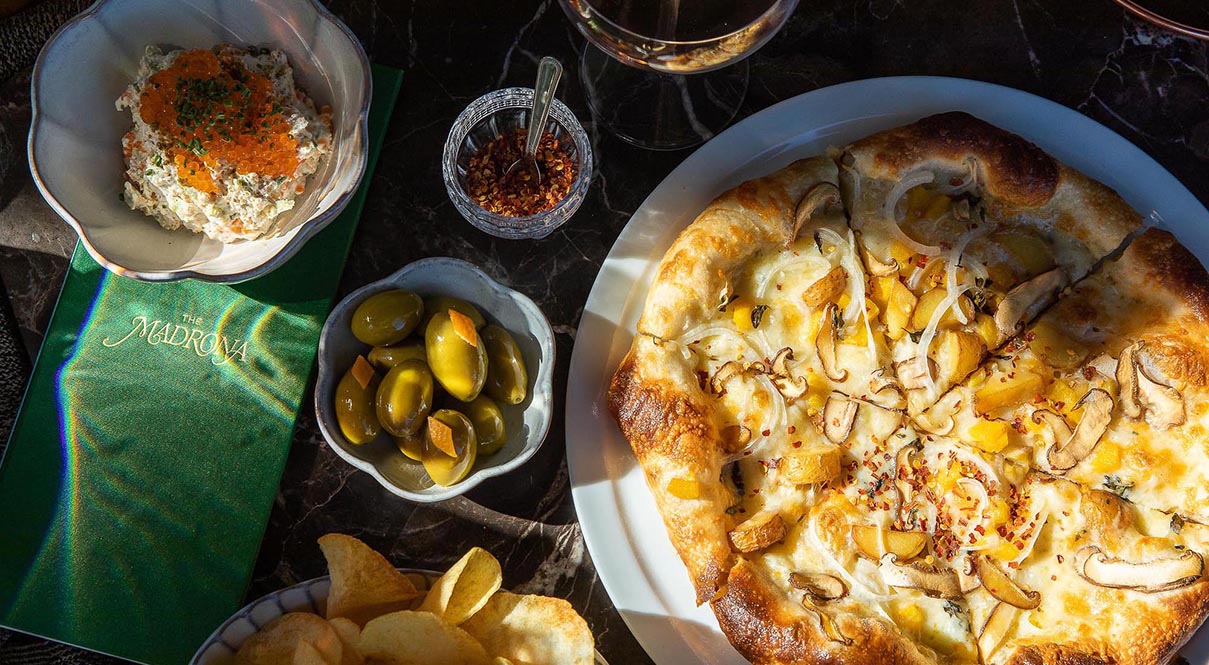 Pizza, olives, caviar and onion dip and a drink at The Madrona